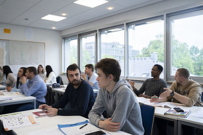 Multi-ethnic students discussing and learning in classroom