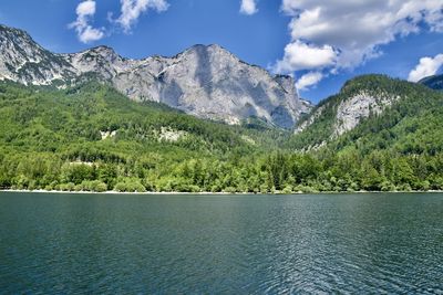 Scenic view of lake by mountains against sky