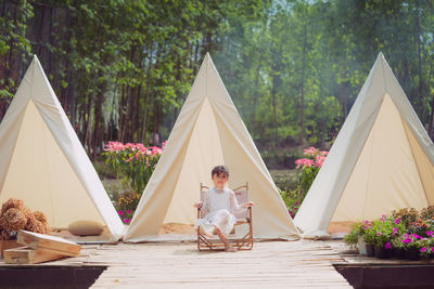 Rear view of cute asian girl with three tent against plants