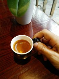 Close-up of hand holding coffee cup