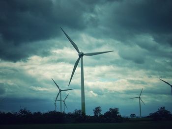 Traditional windmill on field against cloudy sky