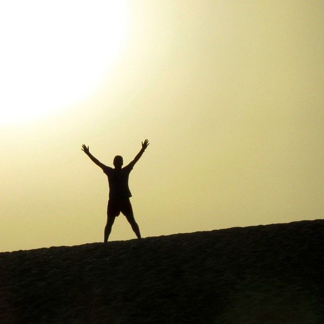 SILHOUETTE OF MAN ON LANDSCAPE AGAINST SKY