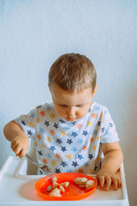 Close-up of boy eating food at home