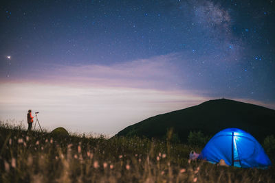 People on field against sky at night