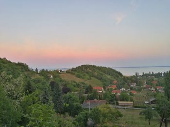 Scenic view of green landscape and sea against sky