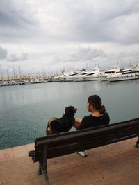 Two men sitting on boat against sky
