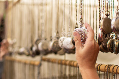 Cropped hand of person holding pocket watch at store