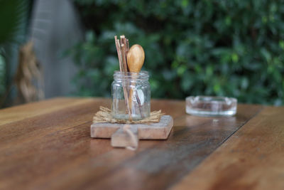 Close-up of stick with spoon in jar on table