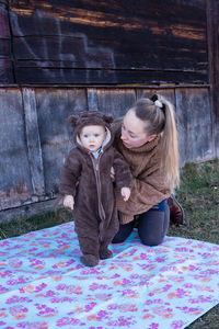 Woman holds her baby from behind. mother and son.