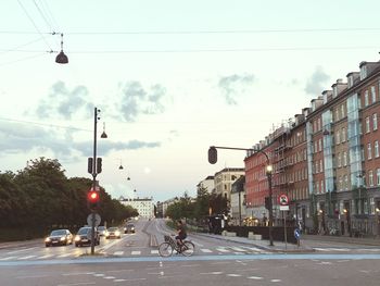 Cars on road against sky in city