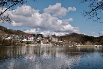 Scenic view of lake by buildings against sky