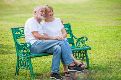 Full length of man sitting on seat in park