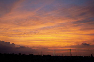 Silhouette landscape against dramatic sky during sunset