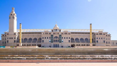 Buildings in city against clear blue sky