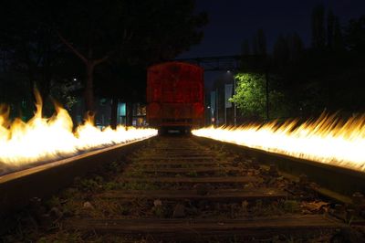 Railroad tracks against sky at night