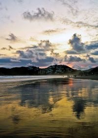 Reflection of clouds in sea at sunset