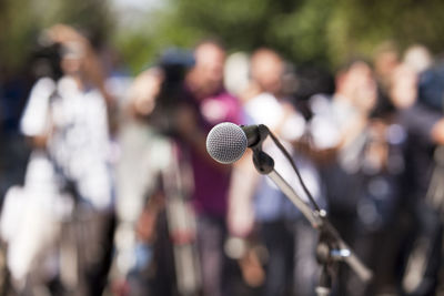 Close-up of microphone with people in background