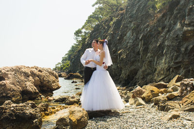 Rear view of couple kissing on rock