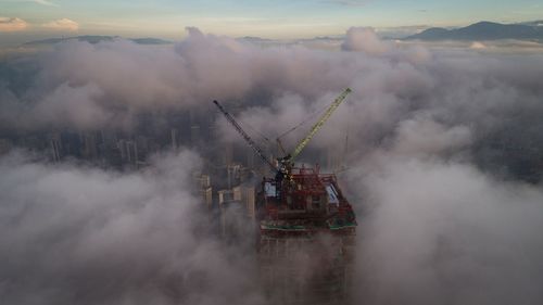 Crane in water against sky