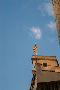 Low angle view of flag on building against sky