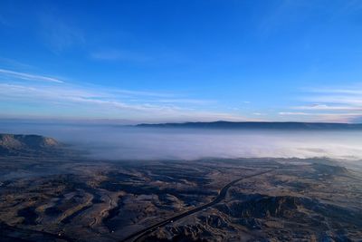 Aerial view of landscape against blue sky