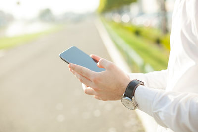 Midsection of man using mobile phone