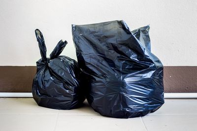 Garbage bags on floor against wall