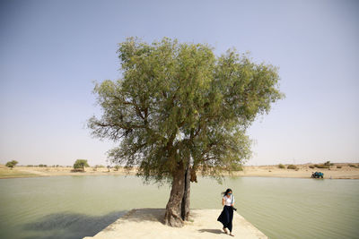 Man standing on beach against clear sky