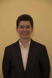 Portrait of smiling businessman standing against yellow background