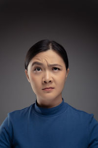 Portrait of teenage boy against gray background