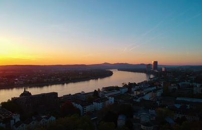 High angle view of buildings and sea against sky during sunset