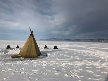 Panoramic view of snow covered land and sea against sky