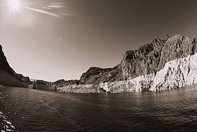 Sun shining through clouds over mountains