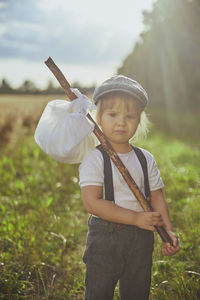 Adorable sad street child in a field at sunset