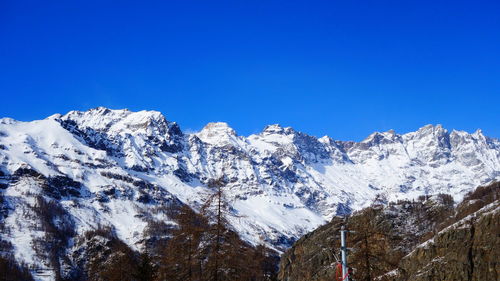 Snowcapped mountains against clear blue sky