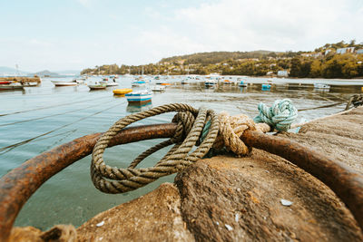 Close-up of rope tied to bollard against sky