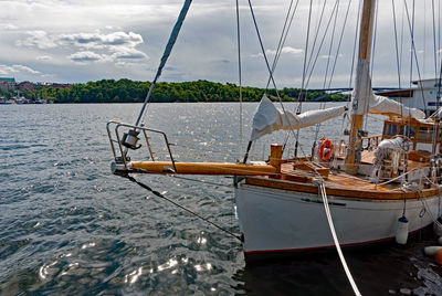 Fishing boat sailing in sea against sky