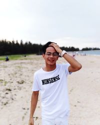 Portrait of young man standing on beach