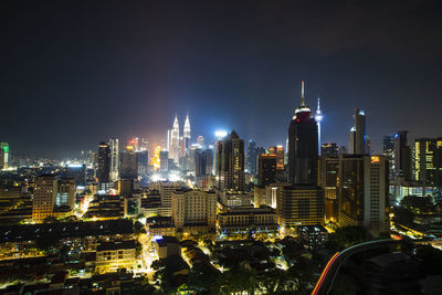 Illuminated cityscape against sky at night