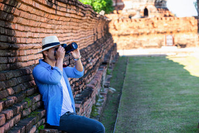 Foreign tourists traveling in the old city of ayutthaya, thailand. young man visiting ayutthaya.