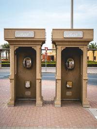 Two telephone booth against sky in city