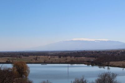 Scenic view of lake against clear blue sky