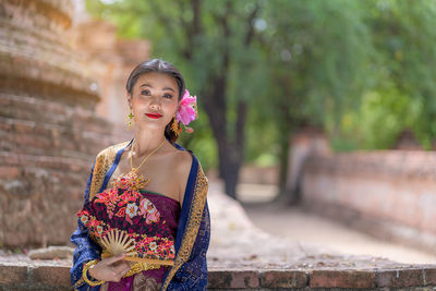 Portrait of smiling young woman wearing traditional clothing standing outdoors