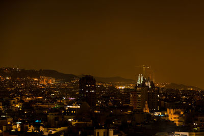 High angle view of illuminated buildings against sky at night