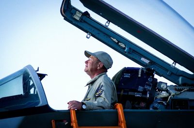 Low angle view of man on airplane against sky