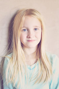 Close-up portrait of girl against wall