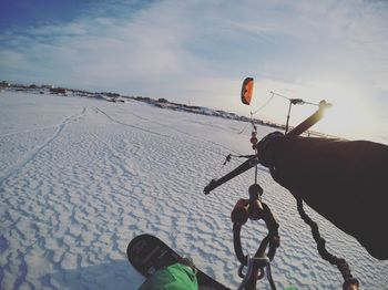 People on snow covered land against sky