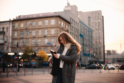 Woman using mobile phone in city