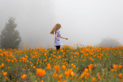 Woman standing on field against sky