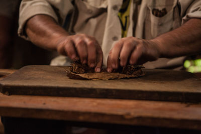 Close-up of hands rolling tobacco